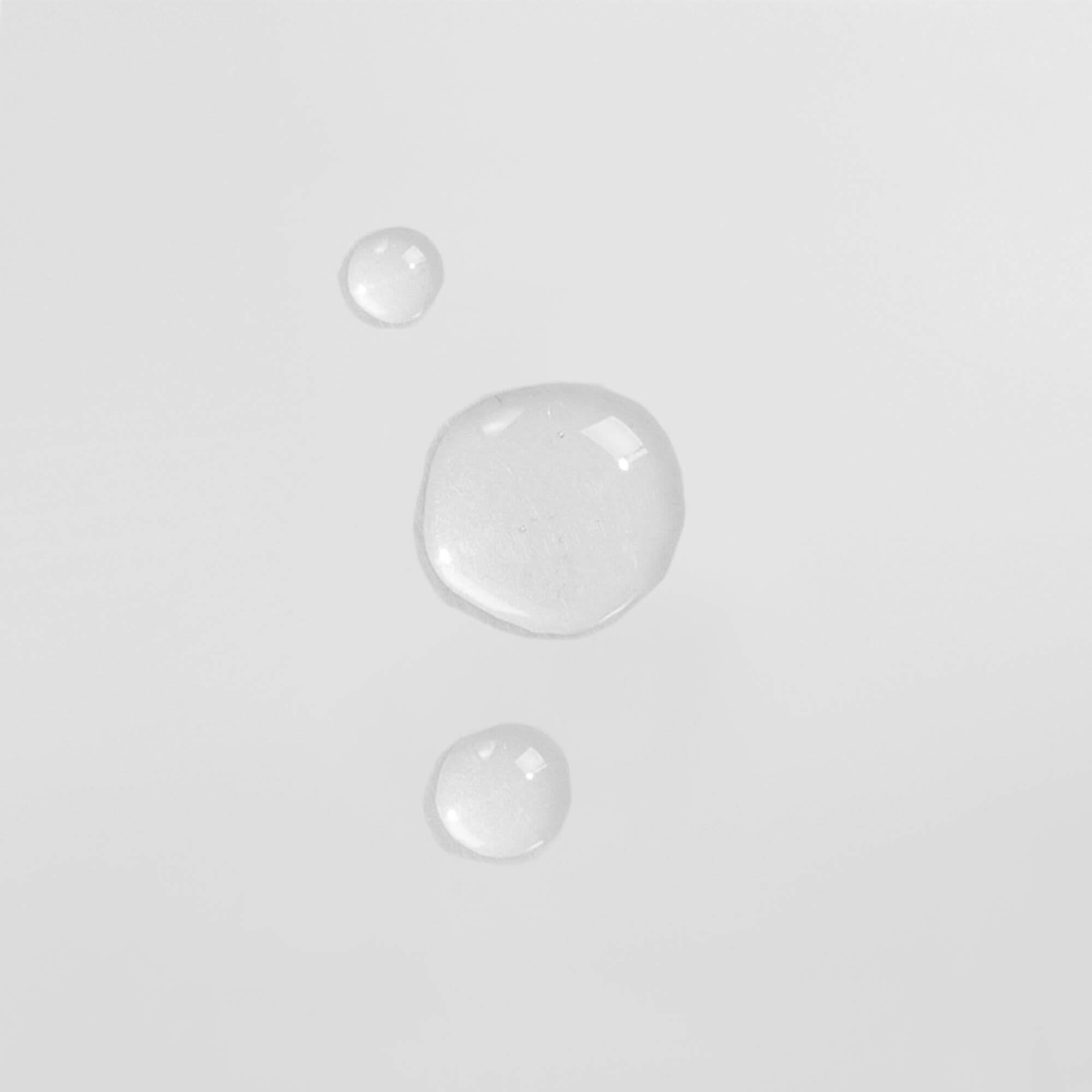 Drei transparente Wassertropfen auf weißem Hintergrund.