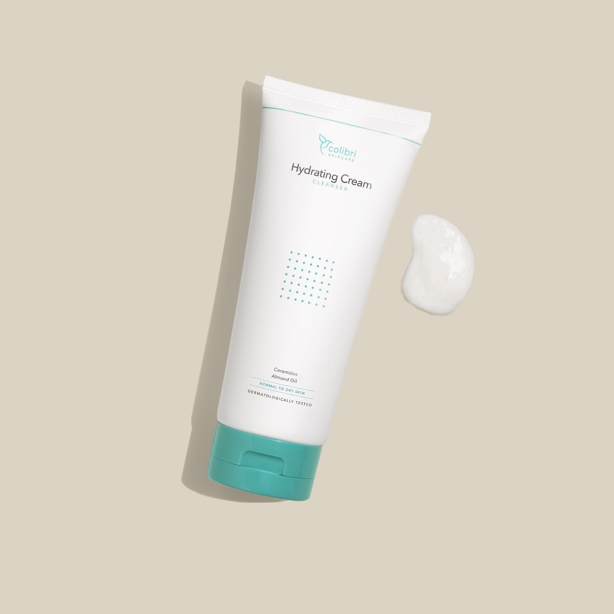 Weiße Tube mit türkisfarbenem Deckel und Aufschrift „Hydrating Cream Cleanser“, daneben eine Portion Creme auf beigem Hintergrund.