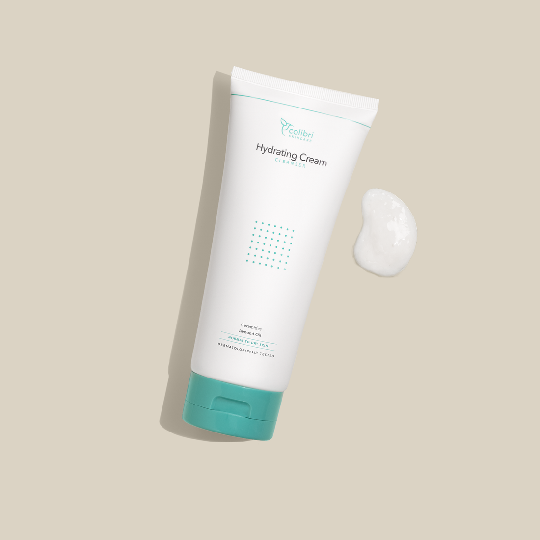 Weiße Tube mit türkisfarbenem Deckel und Aufschrift „Hydrating Cream Cleanser“, daneben eine Portion Creme auf beigem Hintergrund.